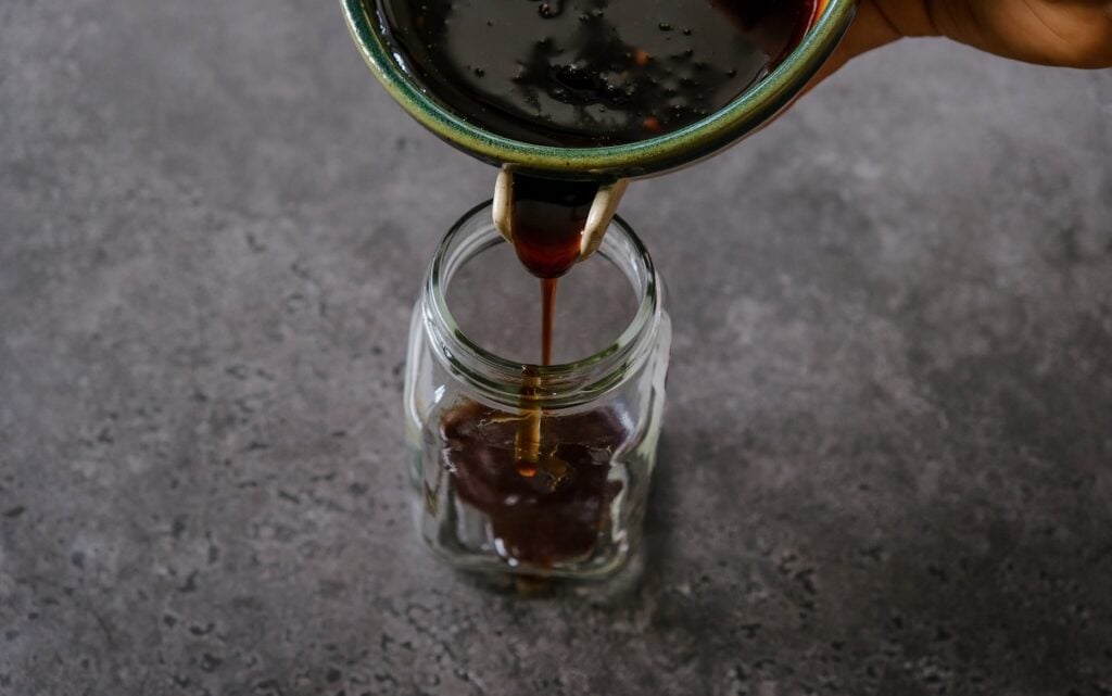 easy homemade teriyaki sauce being poured into a glass jar for storage