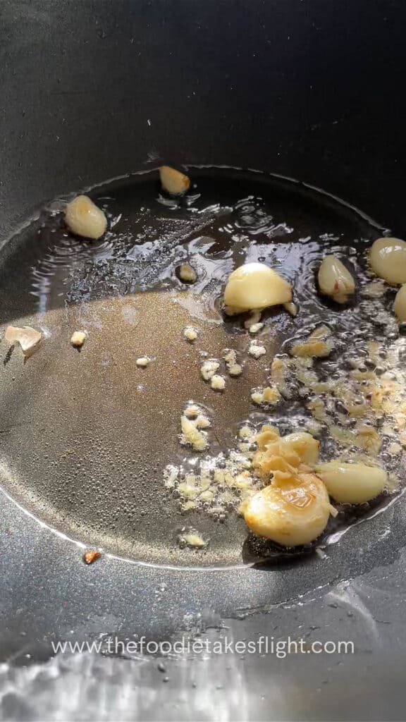 Stir-frying whole garlic cloves and ginger