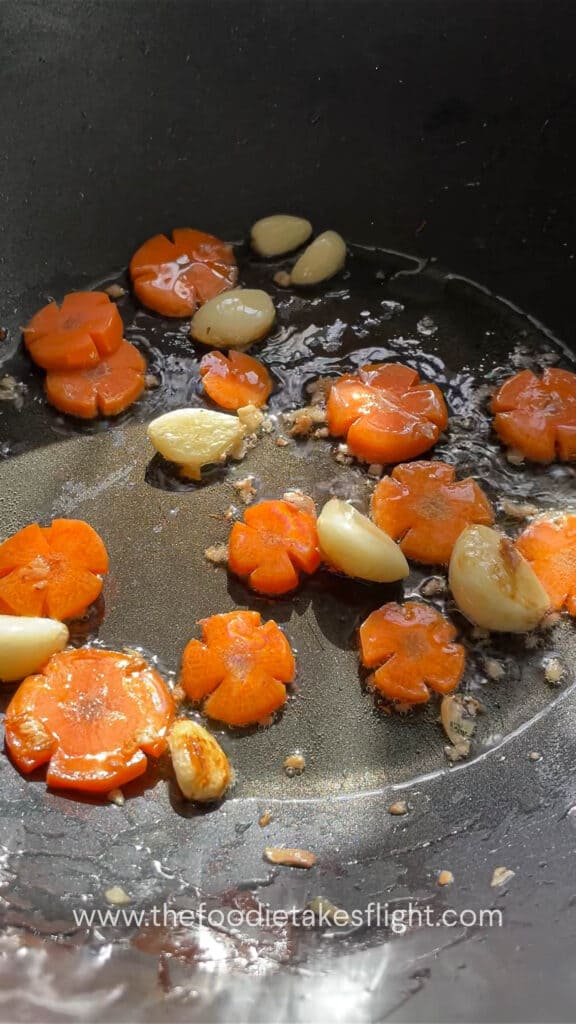 Stir-frying whole garlic cloves, ginger, carrots