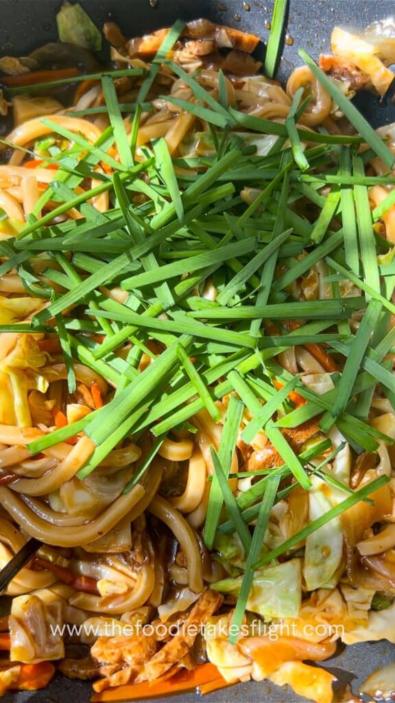 chinese chives mixed in saucy udon noodles