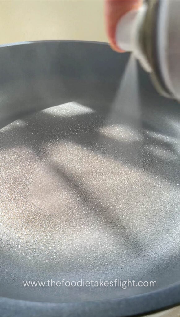 spraying the pan with oil