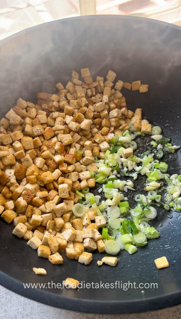 stir frying extra firm tofu and curry leaves