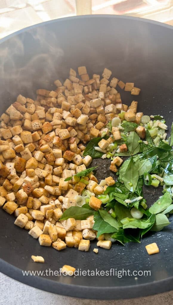 stir frying extra firm tofu and curry leaves