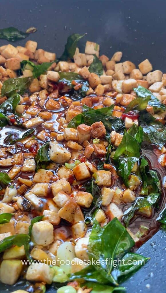 stir frying extra firm tofu and curry leaves