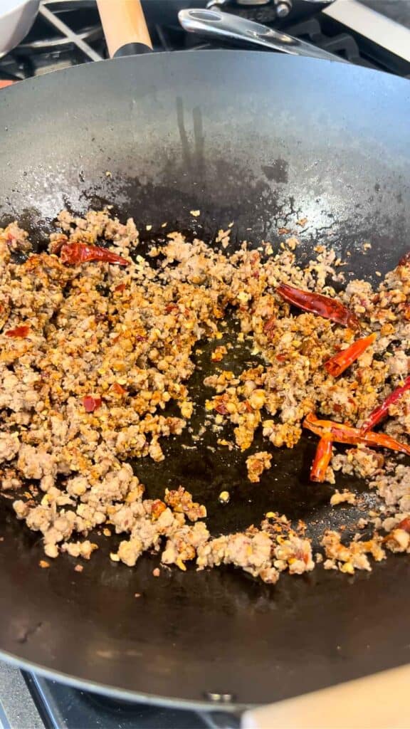 adding doubajiang to meat and aromatic mixture