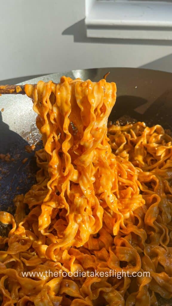 sweet chili tahini noodles in a wok