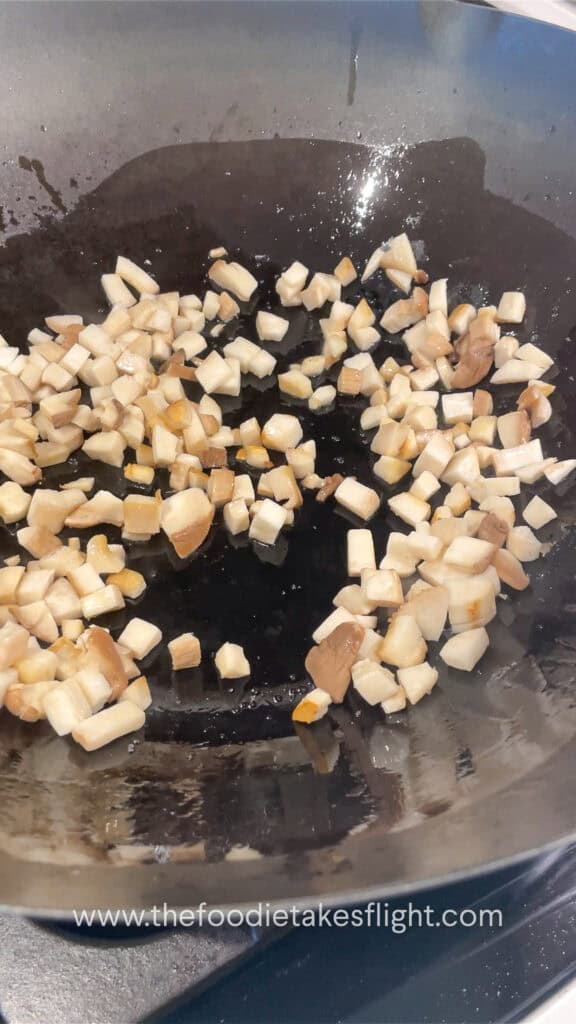 stir frying king oyster mushrooms in a wok