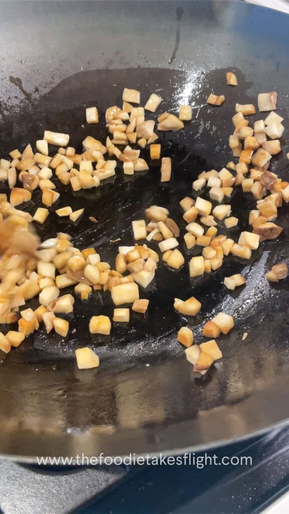 stir frying king oyster mushrooms in a wok