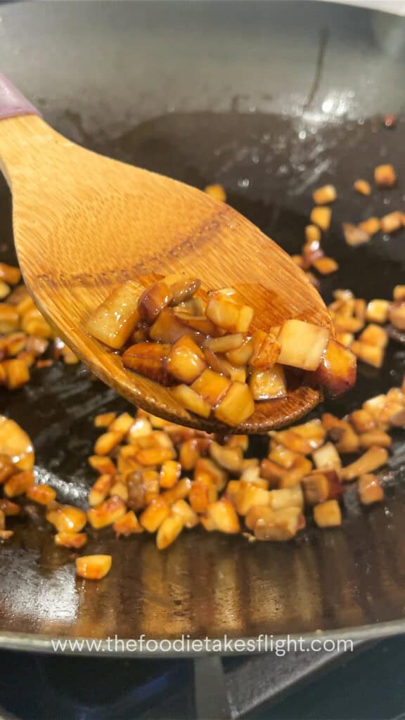 stir frying king oyster mushrooms in a wok