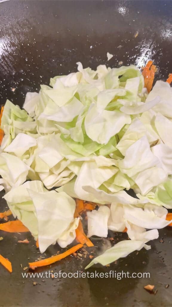 stir frying cabbage and carrot in aromatics