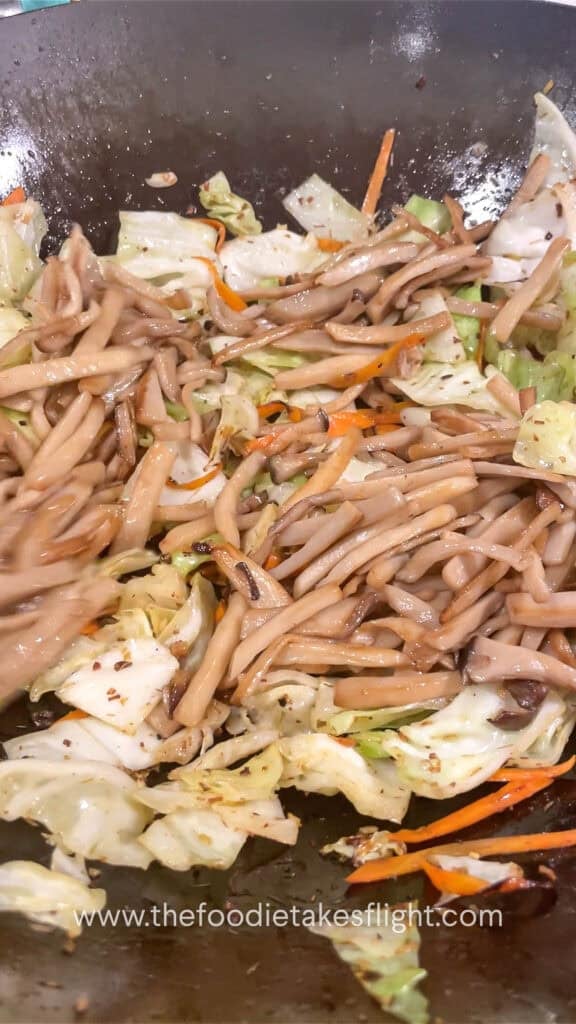 stir frying mushroom, cabbage, and carrot in aromatics