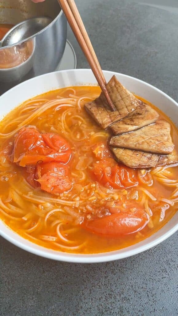 making tomato noodle soup bowl