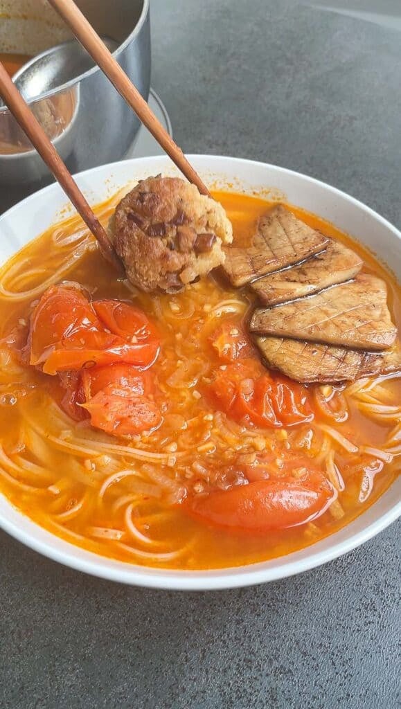 making tomato noodle soup bowl