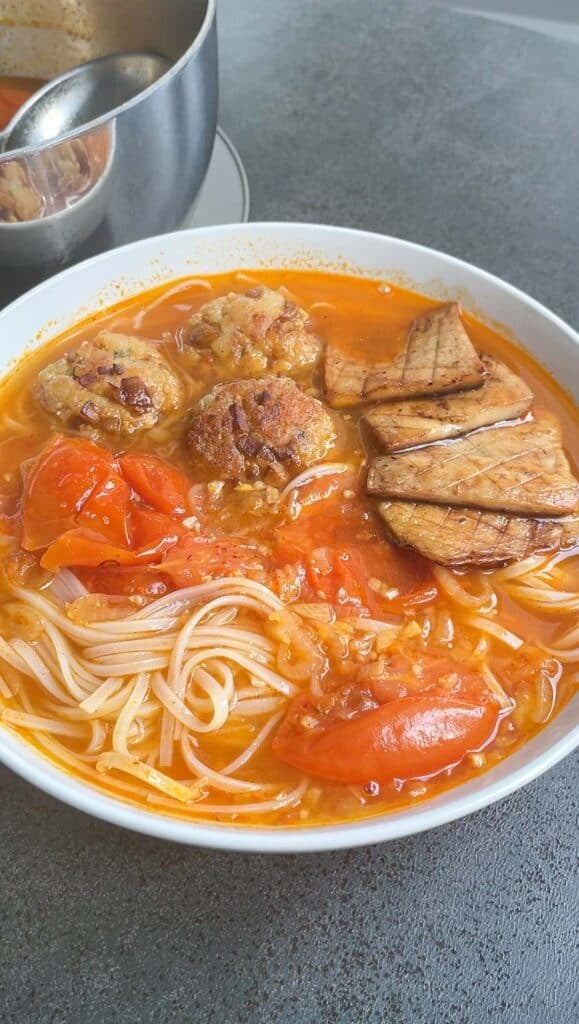 making tomato noodle soup bowl