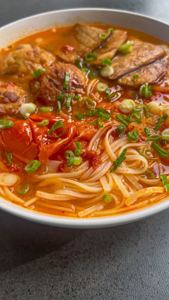 making tomato noodle soup bowl