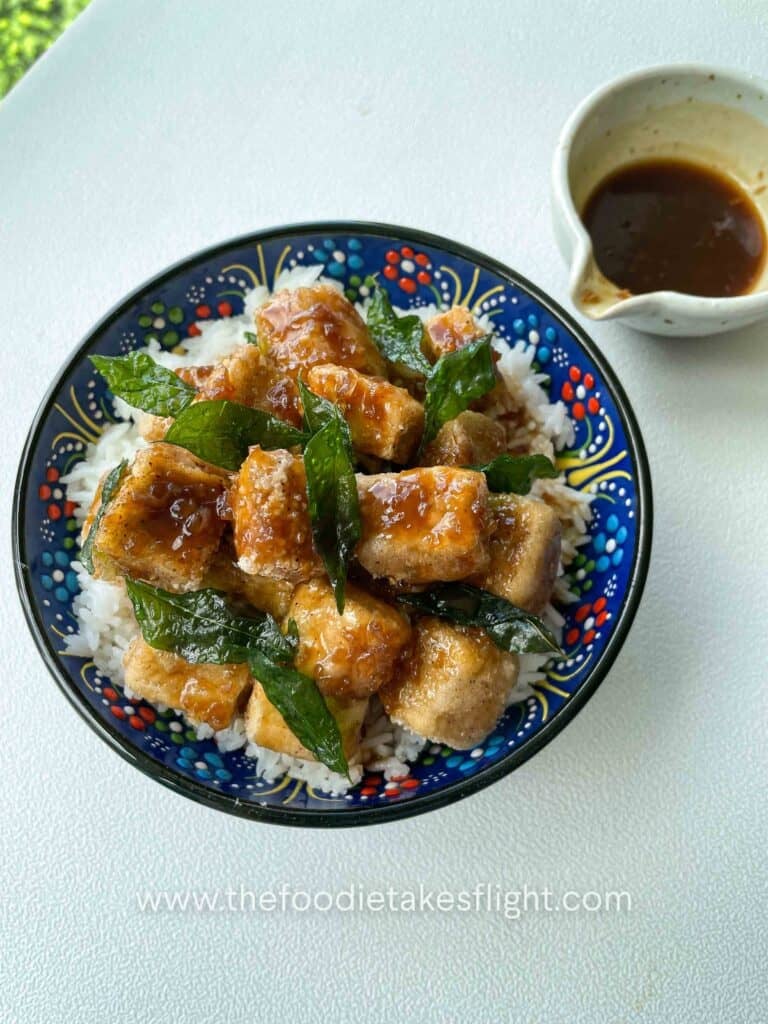 Crispy golden tofu cubes coated in a glossy soy citrus glaze, served with rice and garnished with fried curry leaves