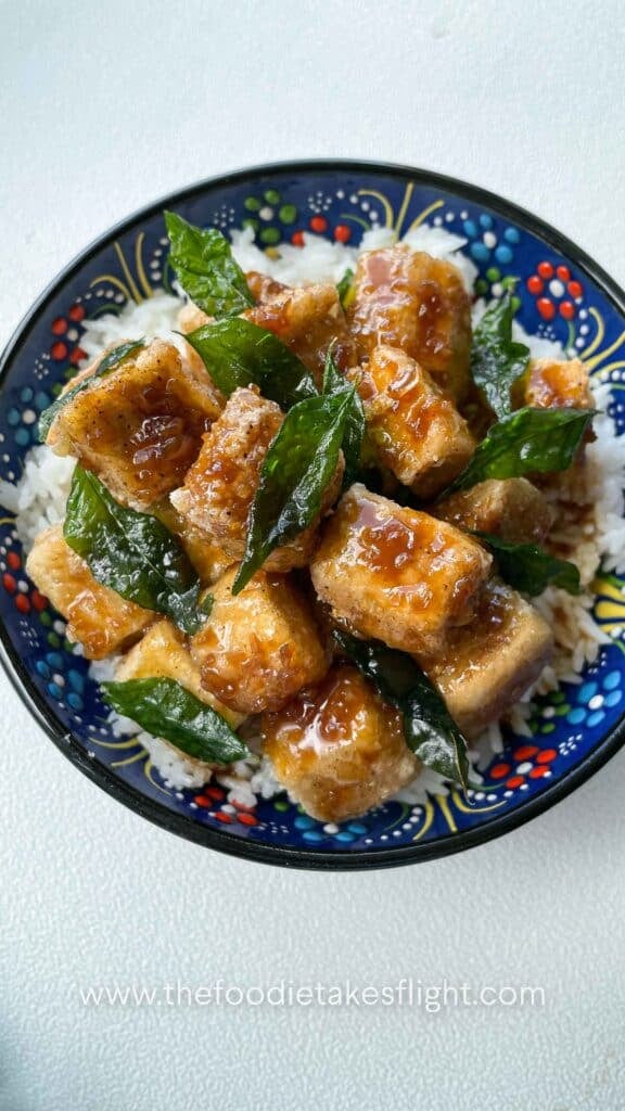 Crispy golden tofu cubes coated in a glossy soy citrus glaze, served with rice and garnished with fried curry leaves