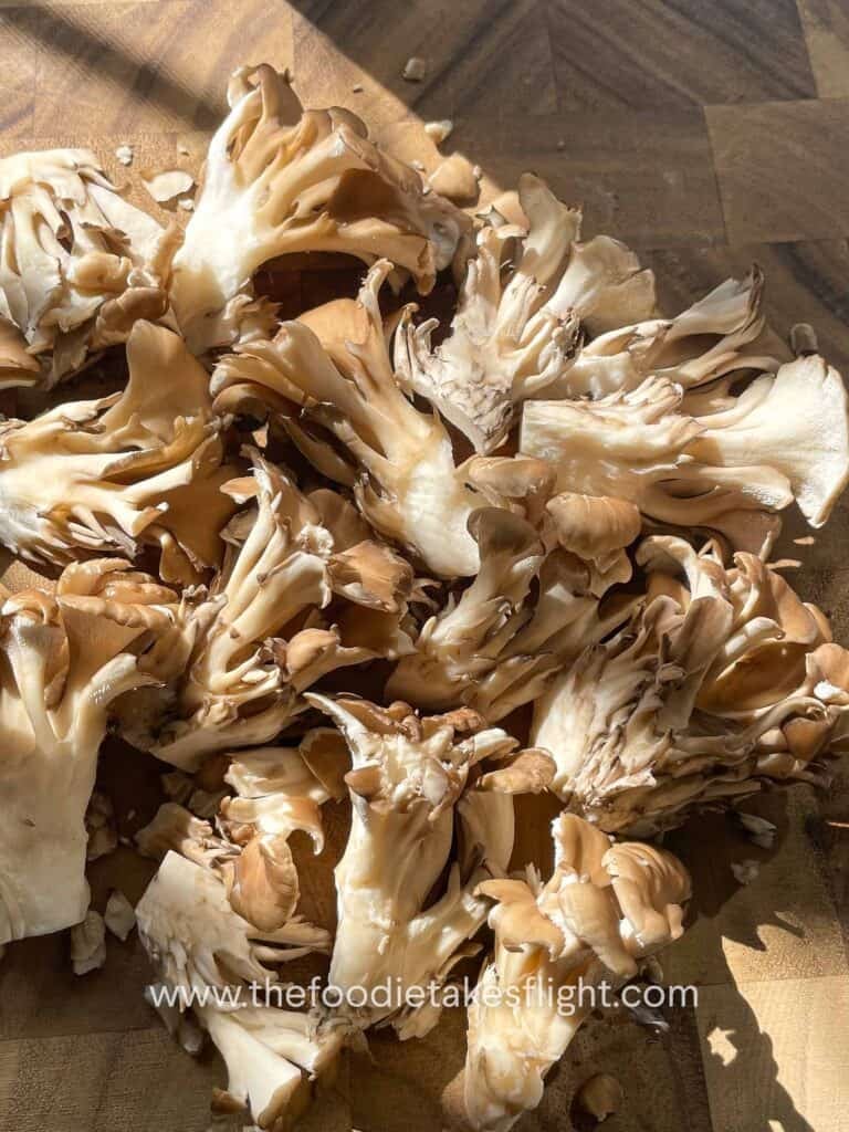 broken apart clusters of fresh hen of the wood or maitake mushrooms