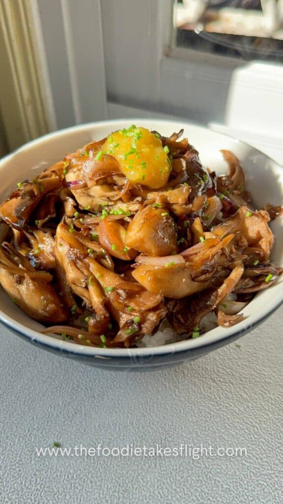 Seared maitake mushrooms over steamed rice, drizzled with ginger teriyaki sauce and chili oil, topped with chopped chives and yuzu