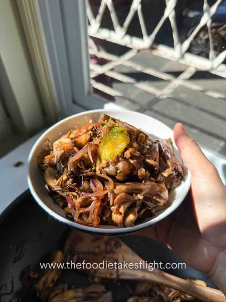 Seared maitake mushrooms over steamed rice, drizzled with ginger teriyaki sauce and chili oil, topped with chopped chives and yuzu
