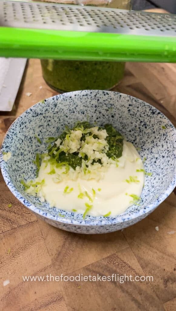 Small bowl of vegan pesto mayo with visible lime zest and finely minced garlic on top