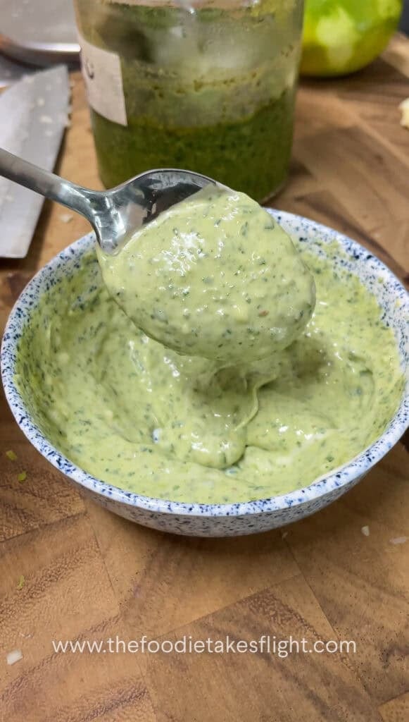 Small bowl of vegan pesto mayo with visible lime zest and finely minced garlic on top