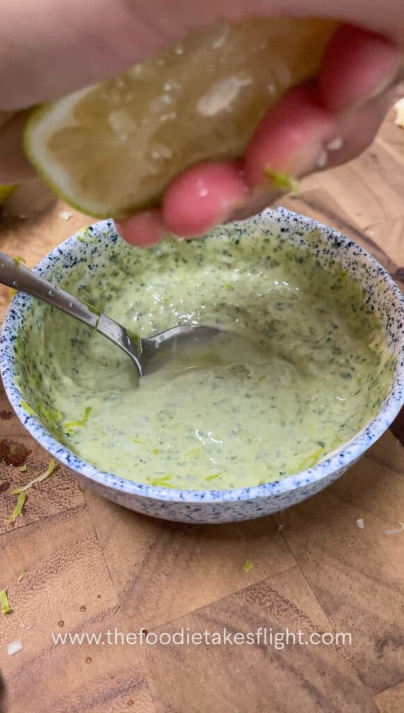 Small bowl of vegan pesto mayo with visible lime zest and finely minced garlic on top