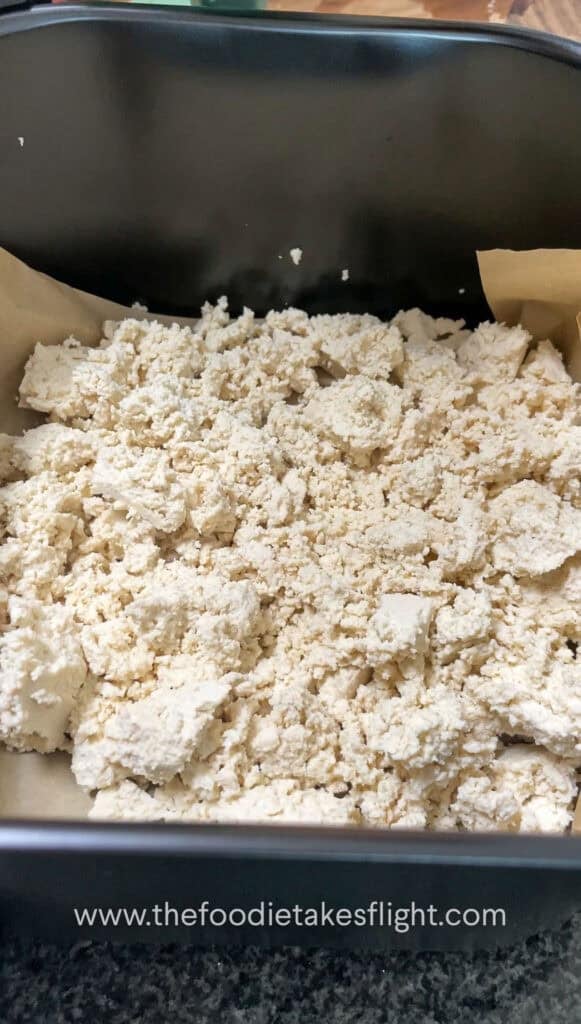 crumbled extra firm tofu in an air fryer basket