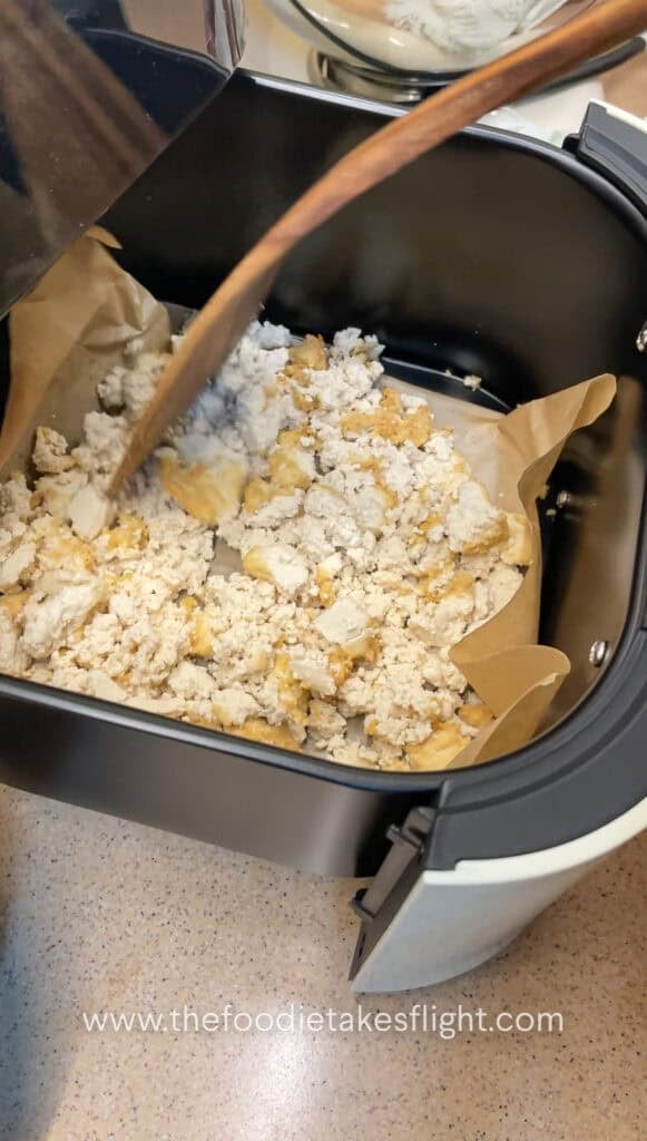 crumbled extra firm tofu in an air fryer basket