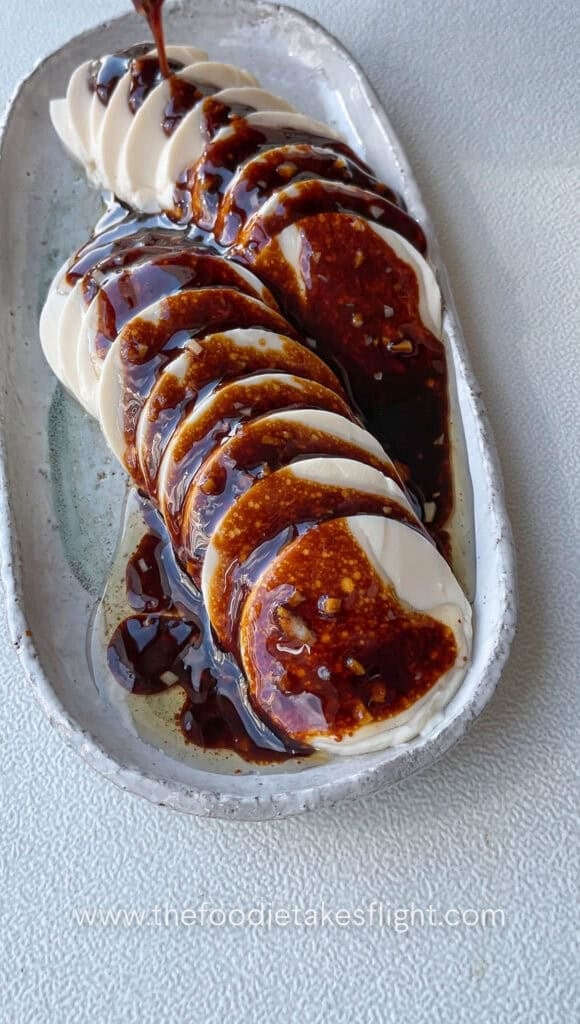 pouring the tasty shallot garlic oil sauce onto the cold silken tofu