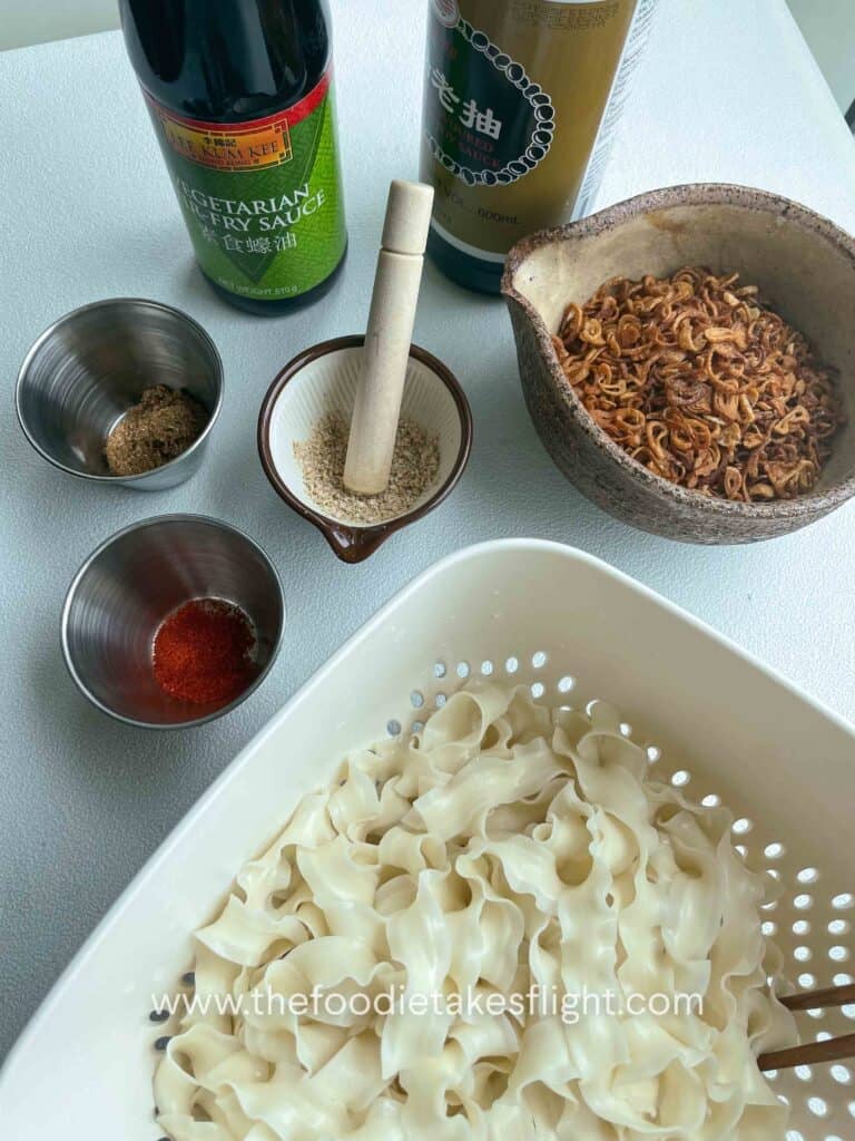 Ingredients for shallot oil noodles including dark soy sauce, gochugaru, cooked knife cut noodles
