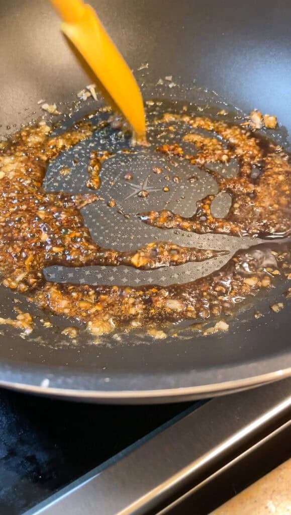 cooking the soy citrus glaze in a wok