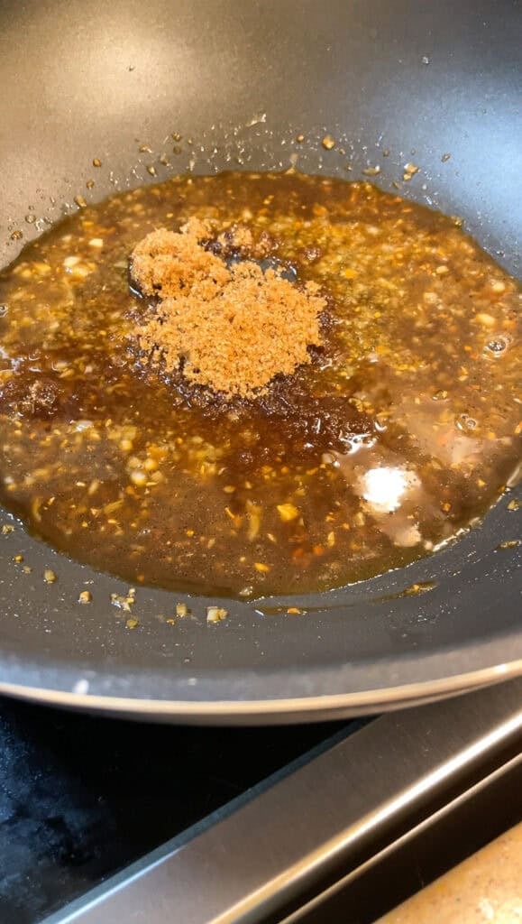 cooking the soy citrus glaze in a wok