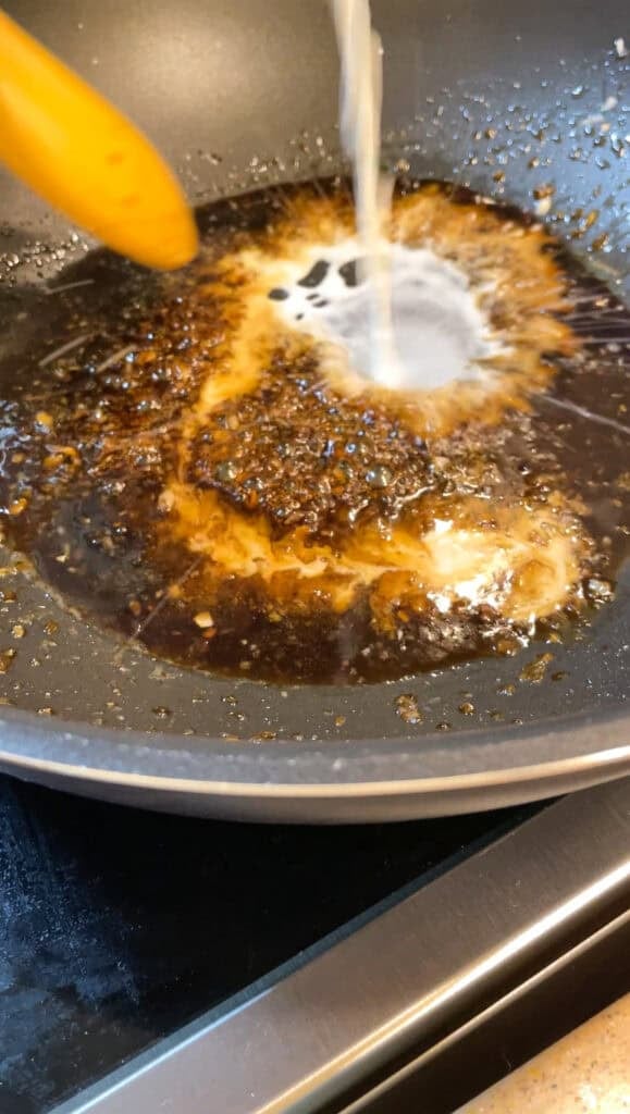 cooking the soy citrus glaze in a wok