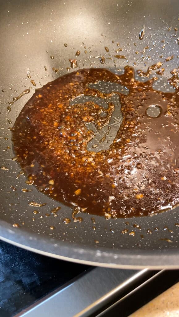 cooking the soy citrus glaze in a wok