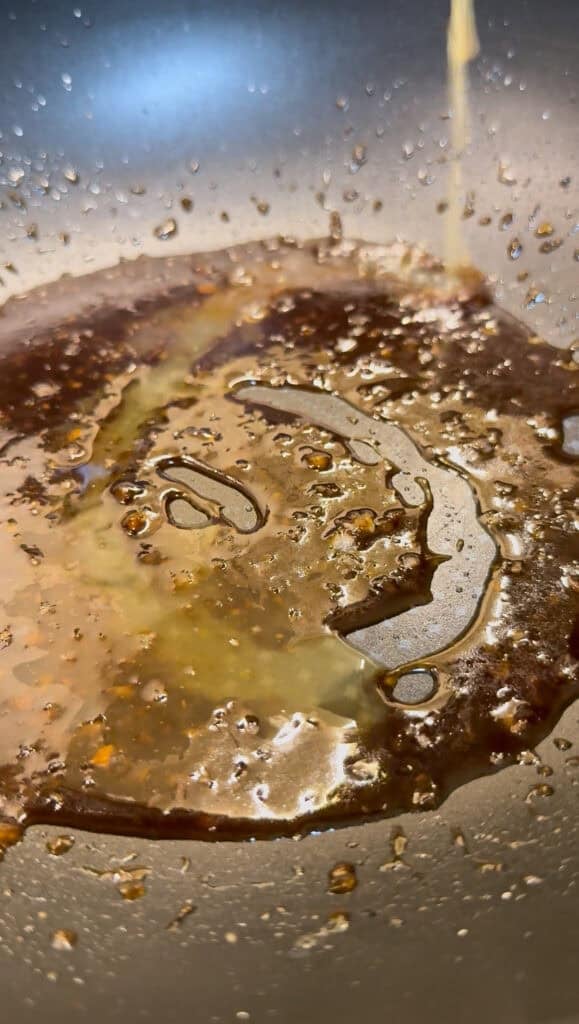 cooking the soy citrus glaze in a wok