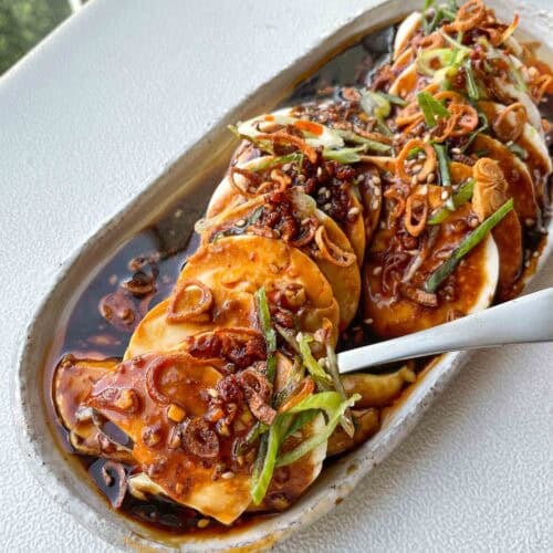 Silken tofu topped with shallot garlic oil, crispy shallots, sliced scallions, chili oil, and sesame seeds