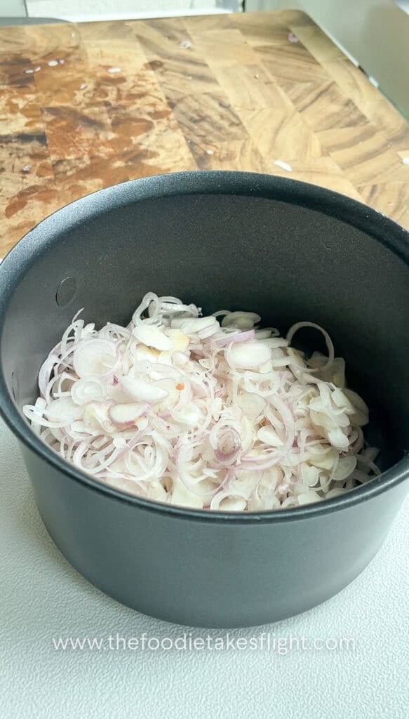 thinly sliced shallots in a pot