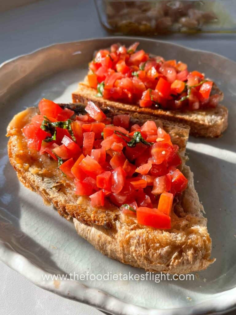 Toasted sourdough slices topped with mashed roasted garlic, fresh tomatoes, basil, and a drizzle of garlic oil