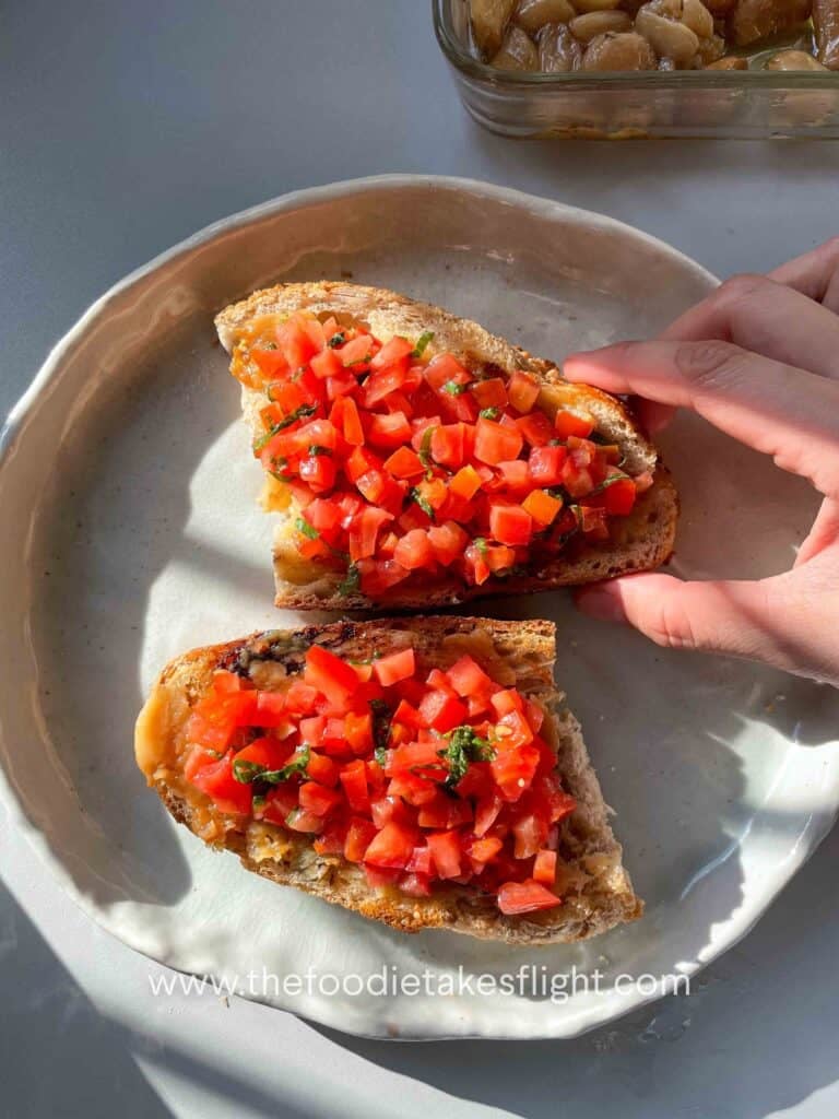 Toasted sourdough slices topped with mashed roasted garlic, fresh tomatoes, basil, and a drizzle of garlic oil