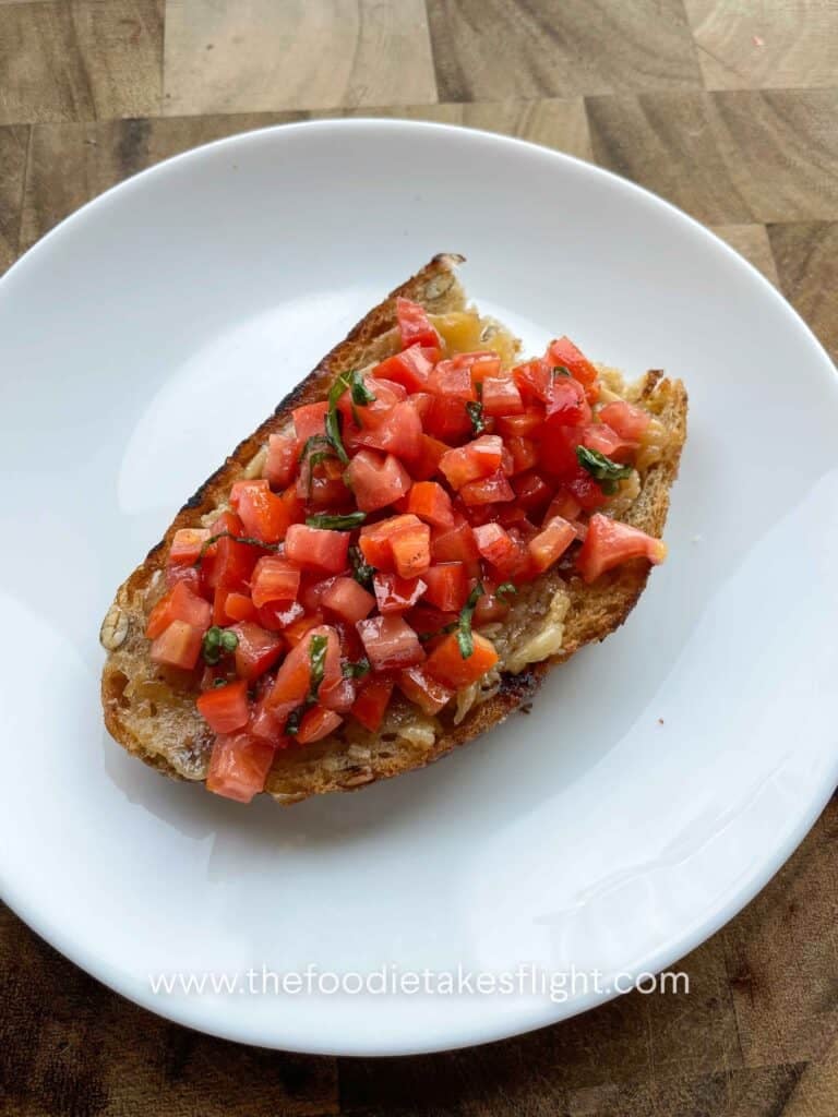 Toasted sourdough slices topped with mashed roasted garlic, fresh tomatoes, basil, and a drizzle of garlic oil