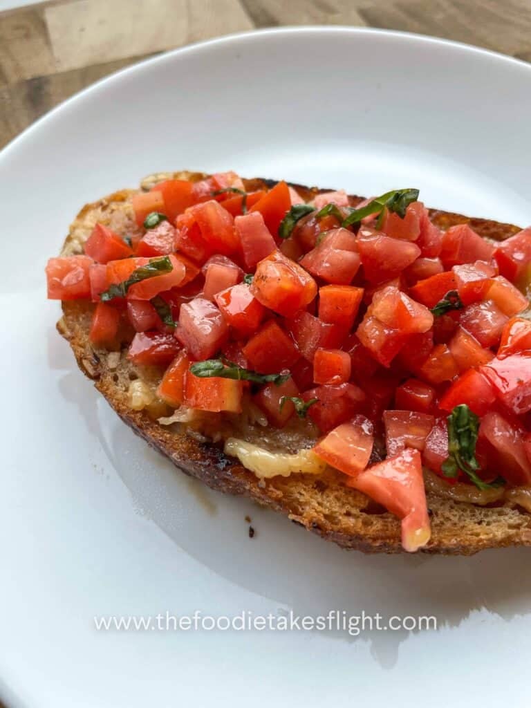 Toasted sourdough slices topped with mashed roasted garlic, fresh tomatoes, basil, and a drizzle of garlic oil