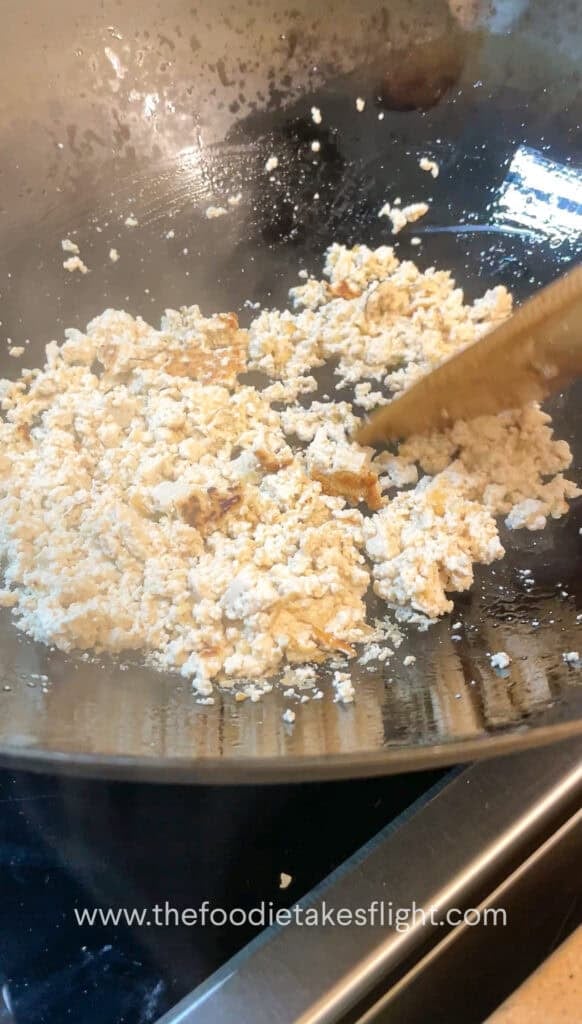 stir-frying crumbled extra firm tofu or tokwa in a pan