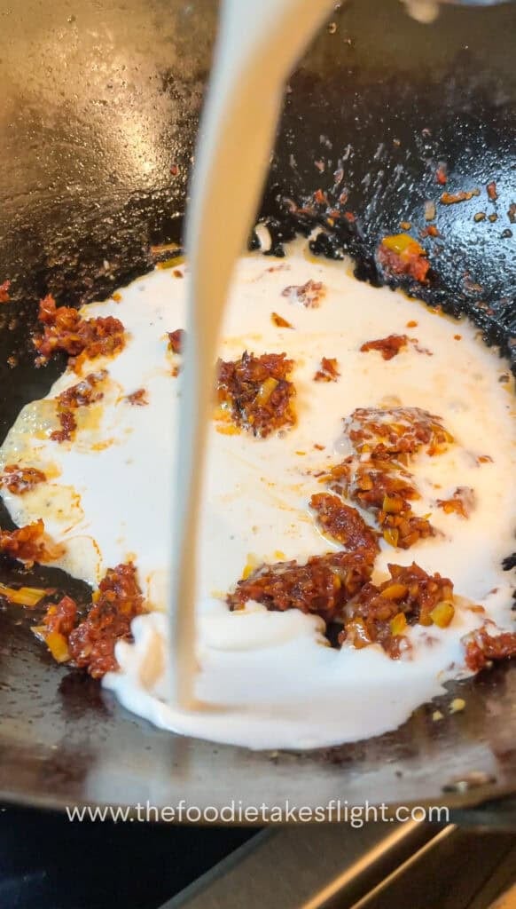creamy tomato coconut sauce simmering in a wok