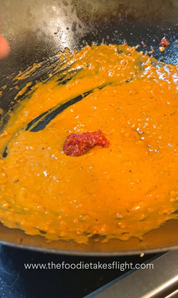 creamy tomato coconut sauce simmering in a wok