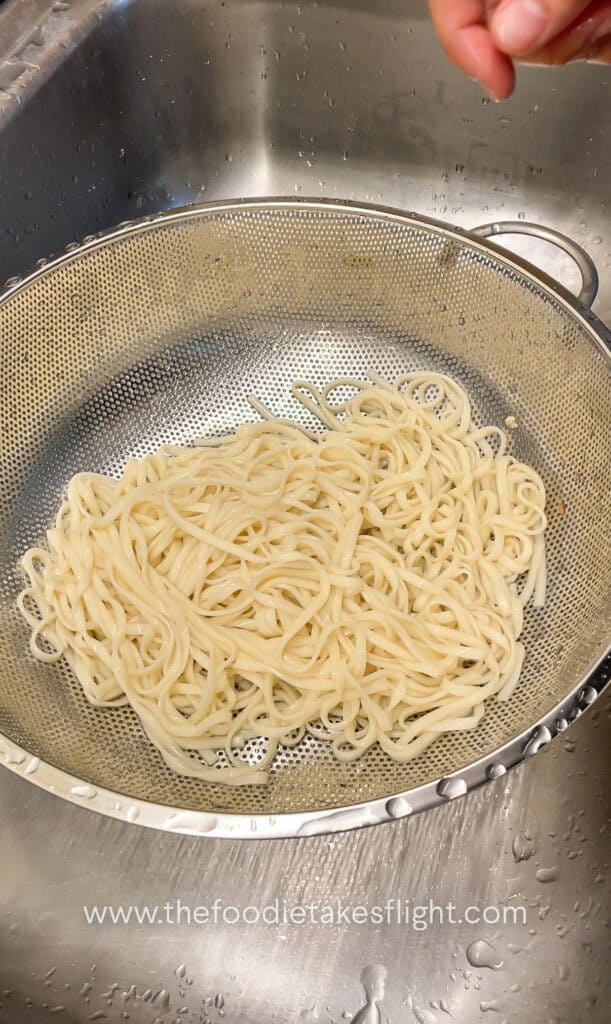 cooking wheat noodles in a pot of hot water