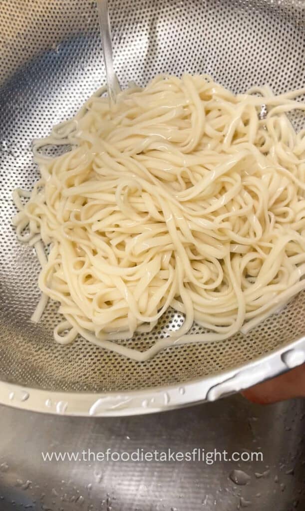 cooking wheat noodles in a pot of hot water