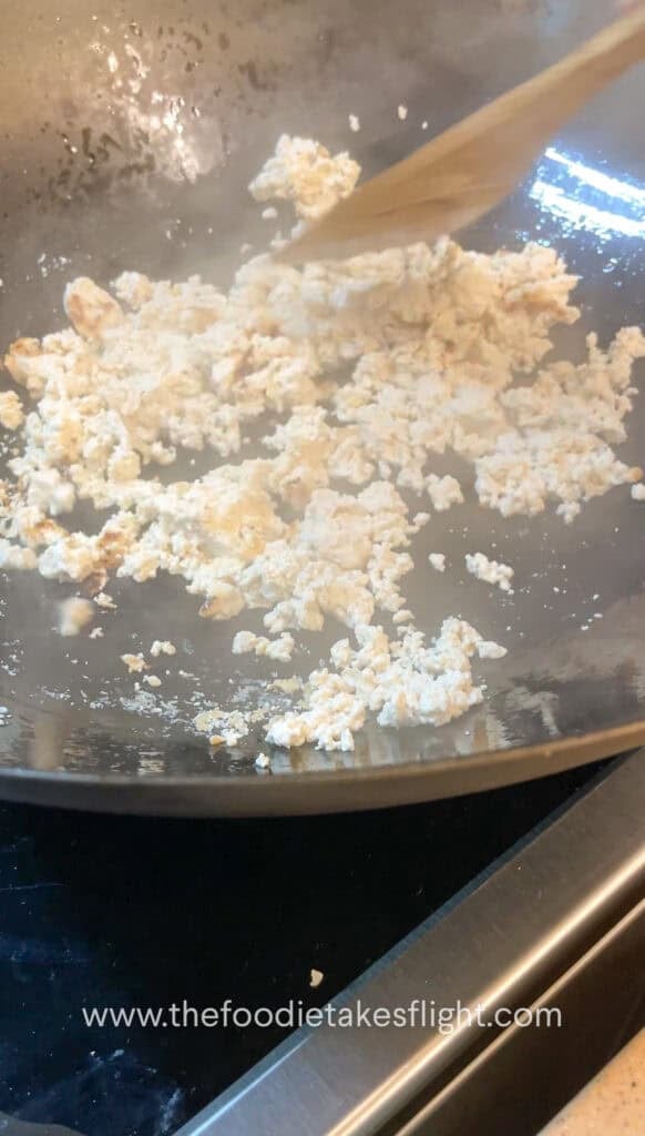 stir-frying crumbled extra firm tofu or tokwa in a pan