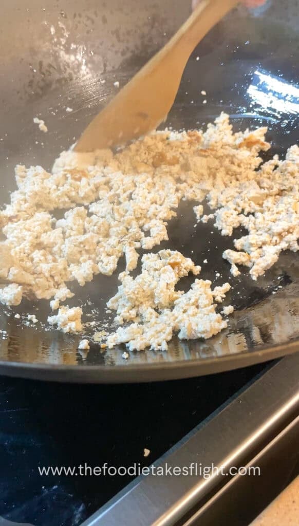 stir-frying crumbled extra firm tofu or tokwa in a pan