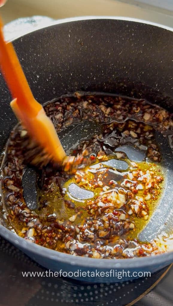 Garlic, chili powder, and Sichuan peppercorn with vegetarian oyster sauce in hot oil in a small pan